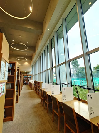 開放的な窓にグラウンドの緑が広がる自習カウンター