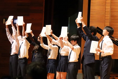 クラスメイトに向かって賞状を掲げる生徒たち