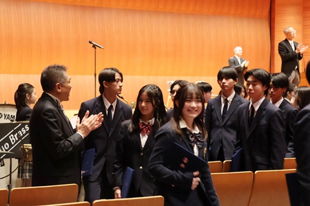 担任の先生に見送られ、笑顔で退場する卒業生たち