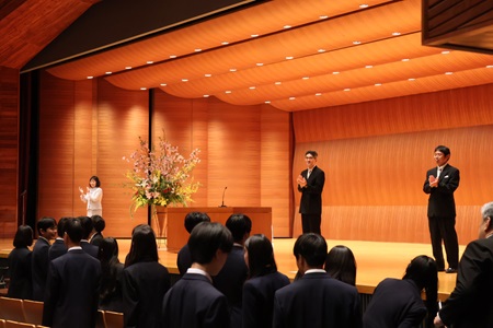 新入生を拍手で迎える校長と副校長 （左から、青柳校長、八木副校長、塚野副校長）