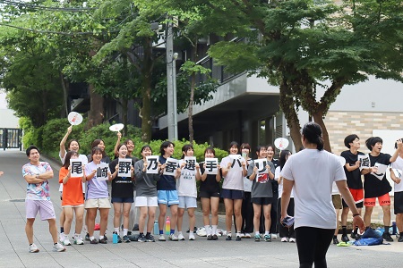 「応援してます！」のメッセージを掲げて生徒たちがお迎え