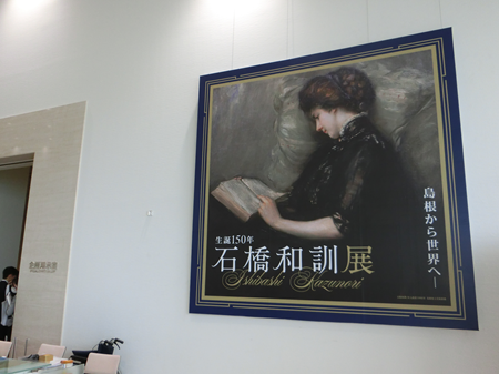 会場入口に飾られた大きなタペストリー（石橋の代表作「美人読詩」）