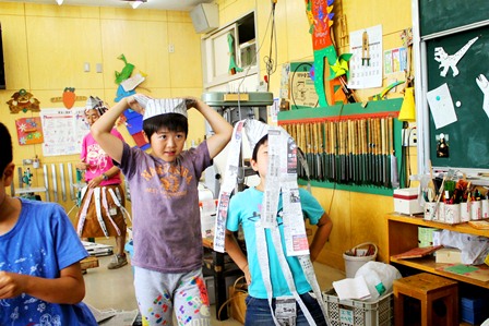 新聞で作った帽子でファッションショー。「どう？似合う？」