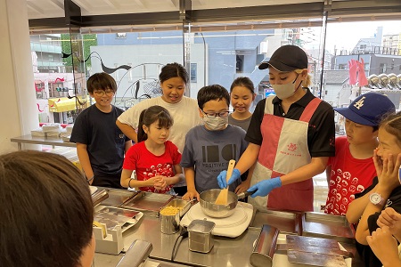 5年葵組は浅草に行ってきました。観光客でにぎわうまちでお昼ご飯をテイクアウト！浅草ならではの”味”を楽しみました。浅草名物「雷おこし」の製造体験にも参加。火力と時間との勝負でしたが、200年以上の伝統ある銘菓は納得のおいしさだったようです。