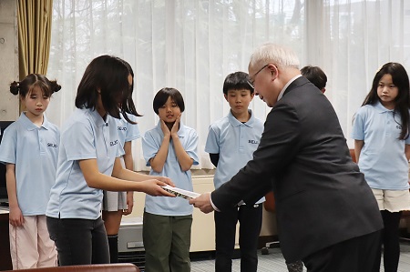 活動の記録をまとめた報告書を学園長に渡しました