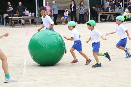 幼稚園児を6年生がサポートして大玉リレー（年中組～6年生）