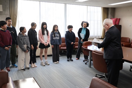 学園長に、活動の記録をまとめた報告書を手渡しました