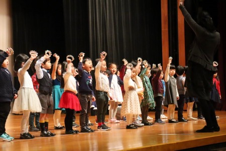 年少組さんは「こどものせかい」に合わせて鈴の演奏。初めて記念講堂のステージに立つとは思えないほど演奏を楽しんでいました