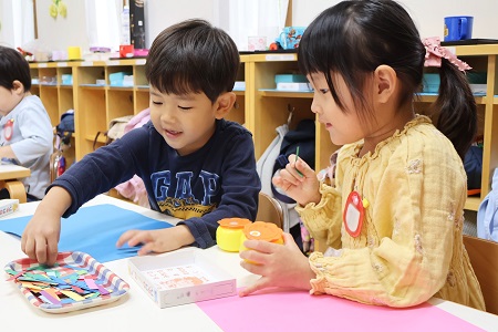 小さく切った色画用紙をのりで台紙に貼っていきます 色選びも作品作りの大切なポイント