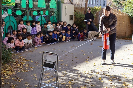 「先生がんばれ！」的に向かって消火器で放水訓練