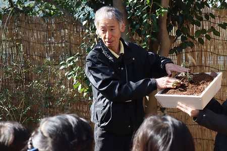苗を植える様子を見せてくれる梅原さん