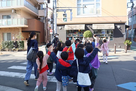 手を挙げて横断歩道を渡る子どもたち